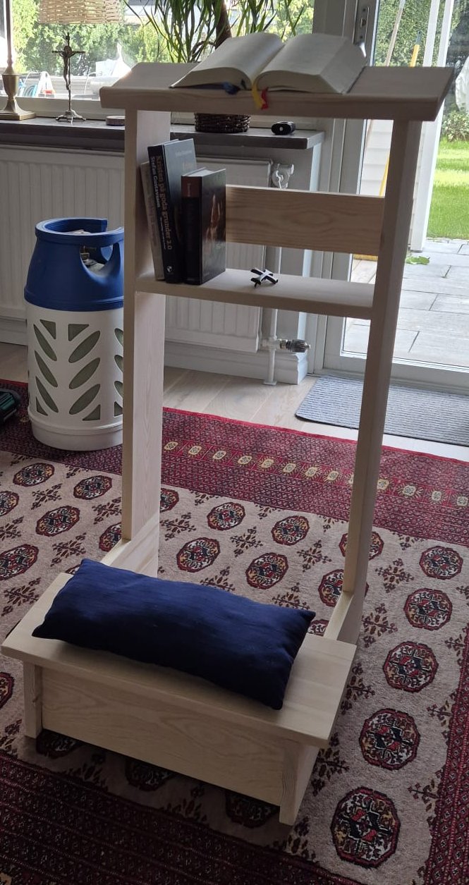 Knäfallsbänk i ljust trä med öppen låda och blå kudde